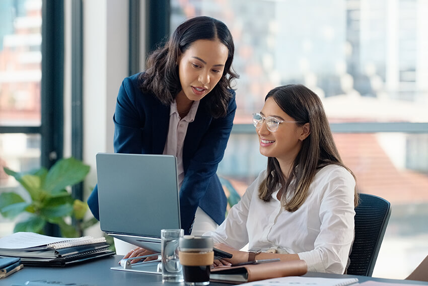 Female coworkers analyzing strategic hiring on a laptop during the 2025 September Surge.