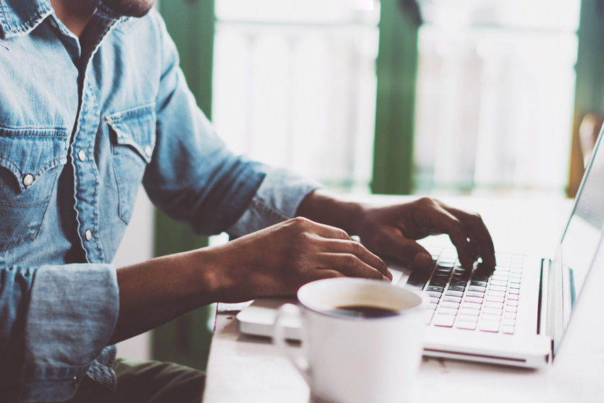 man in denim shirt at laptop