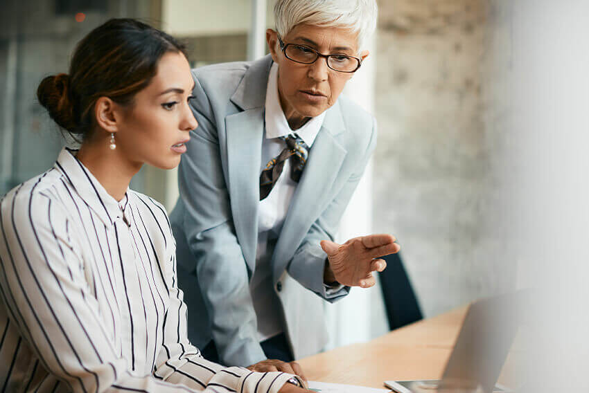 A male mentoring a woman mentee in the workplace.