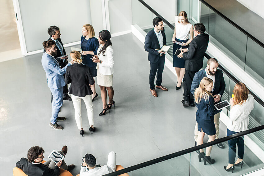 Overhead view of a group of standing people talking. Aston Carter Recruitment Articles.