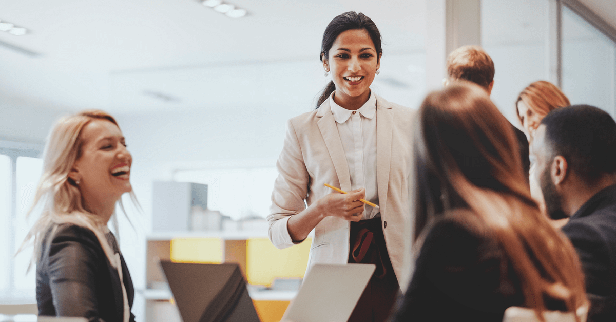 une femme qui sourit à ses collègues au bureau