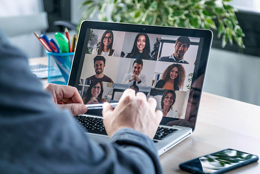 Four diverse empoylees gathered around a computer screen 