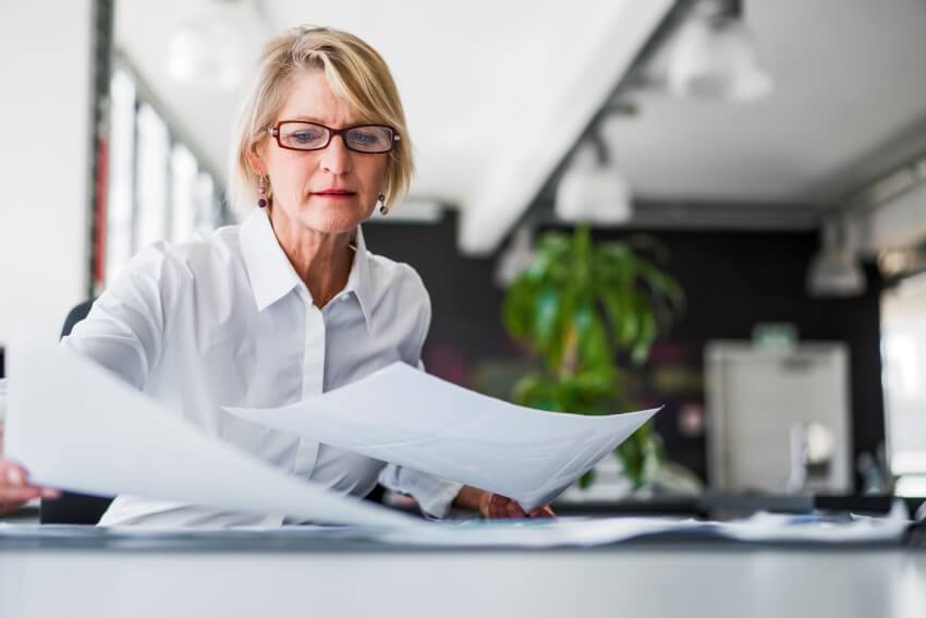 Une femme analysant des documents | Astoncarter.com