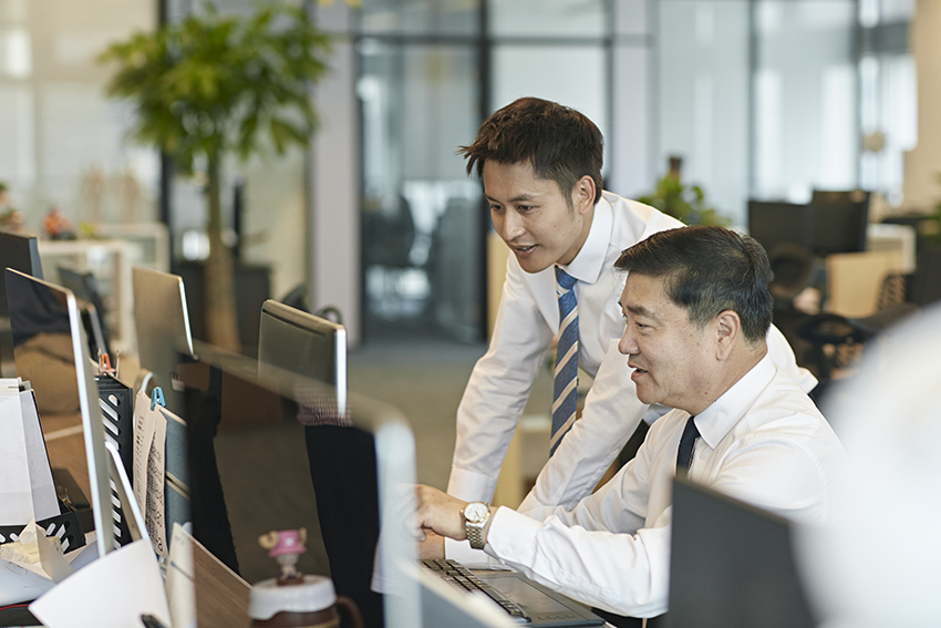 Two colleagues discussing something at their desk