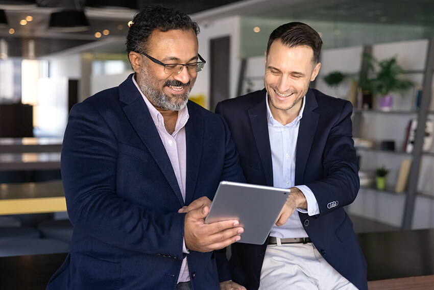 Two male professionals reviewing the Q2 labour report looking at Q2 2026 labour market trends on an iPad.