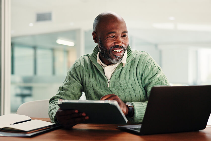 A male professional reviewing the December 2025 jobs report on a laptop looking at November 2025 labor market and economy trends.