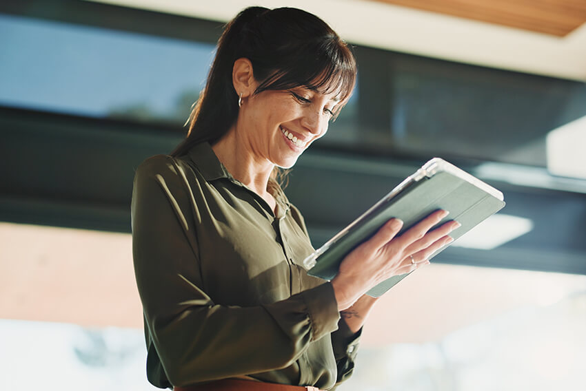Female professional reviewing the February 2026 jobs report on an iPad looking at January 2026 labor market and economy trends.