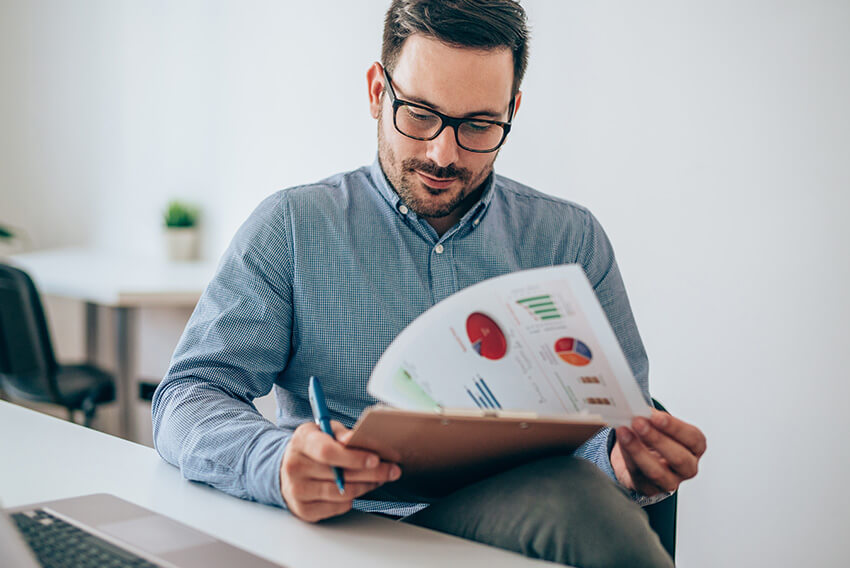Male reading the July 2025 jobs report looking at June 2025 labor market and economy trends.