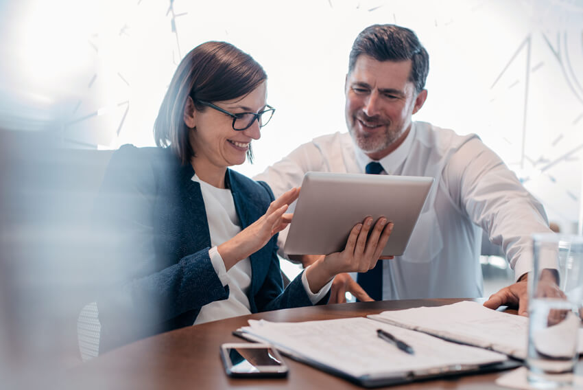 Female and male coworkers reviewing the May 2025 jobs report looking at labor market and economy trends in April 2025.