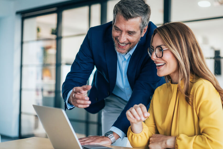 Two professionals reviewing the October 2026 jobs report on a laptop looking at September 2026 labor market and economy trends.